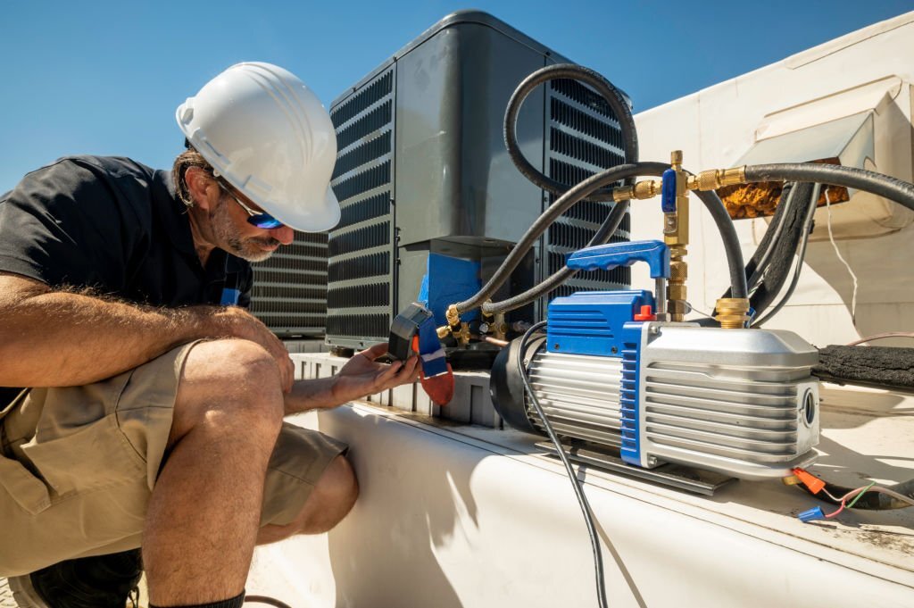 HVAC technician monitoring a vacuum gauge after an air conditioning repair